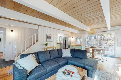 a living room with a blue couch and a table at Saint Bernard Beauty in Lake Arrowhead