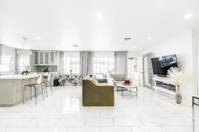 a kitchen and living room with a couch and a tv at New luxury entertaining house with Pool Spa Sauna Tesla charger Pets in Los Angeles