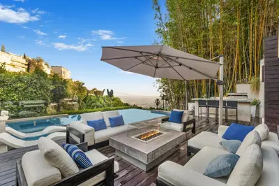 a patio with a couch and an umbrella and a pool at Sunset Heights in Los Angeles