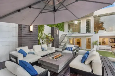 a patio with white furniture and an umbrella at Sunset Heights in Los Angeles