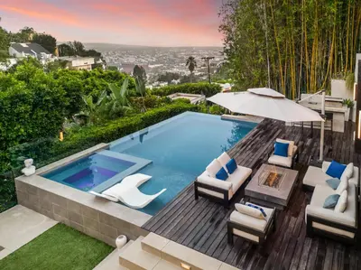 a swimming pool with two chairs and an umbrella at Sunset Heights in Los Angeles