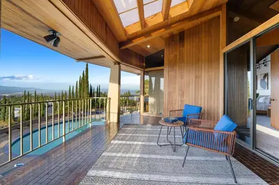 a house with a balcony with a pool and blue chairs at Via Vallarta in Los Angeles