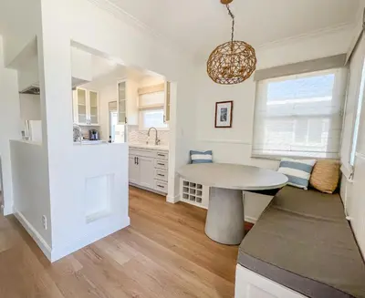 a kitchen and dining room with a table and a window at El Nido Beachlife Cottage in South Bay Los Angeles in Redondo Beach