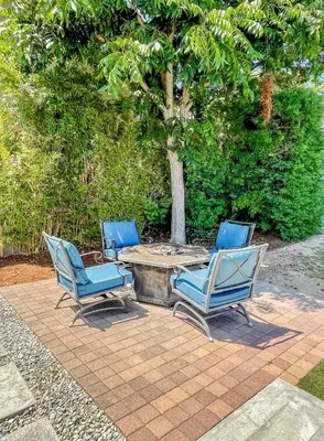 three blue chairs and a table in front of a tree at El Nido Beachlife Cottage in South Bay Los Angeles in Redondo Beach