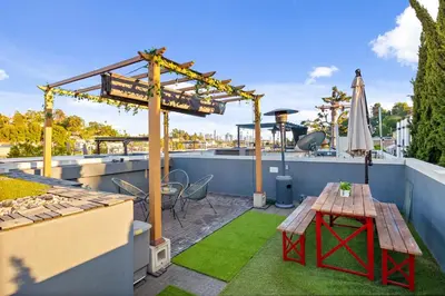 a rooftop patio with a table and a umbrella at Chic Silver Lake Oasis with Breathtaking City Skyline Views, Private Rooftop & Garage in Los Angeles