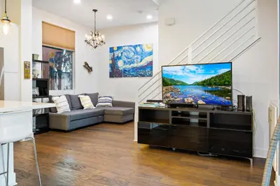 a living room with a flat screen tv on a stand at Chic Silver Lake Oasis with Breathtaking City Skyline Views, Private Rooftop & Garage in Los Angeles