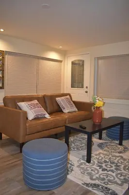 a living room with a brown couch and a table at Charming private guest Suite near Disney/Beach in Westminster