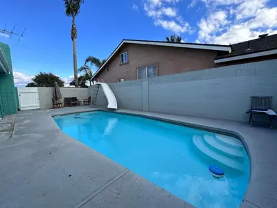 a large swimming pool in a yard next to a fence at Charming private guest Suite near Disney/Beach in Westminster