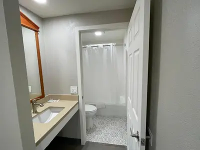 a bathroom with a white toilet and a sink at Villa Inn Anaheim in Anaheim