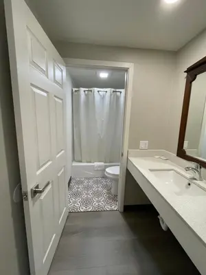 a bathroom with a toilet and a sink and a door at Villa Inn Anaheim in Anaheim