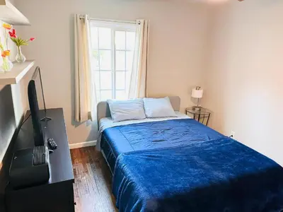 a bedroom with a blue bed and a window at Los Angeles Home Located in Beautiful Pasadena in Pasadena
