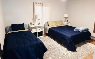 a bedroom with two beds with blue sheets and a rug at Los Angeles Home Located in Beautiful Pasadena in Pasadena