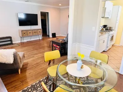 a living room with a glass table and yellow chairs at Los Angeles Home Located in Beautiful Pasadena in Pasadena