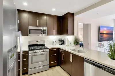 a kitchen with stainless steel appliances and wooden cabinets at 5 Heart of Santa Monica apartment in Los Angeles