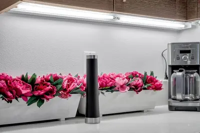 two white containers filled with pink flowers on a counter at 5 Heart of Santa Monica apartment in Los Angeles