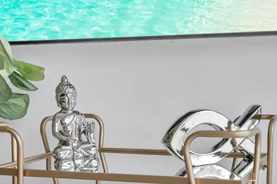 a silver statue sitting on a chair next to a mirror at 5 Heart of Santa Monica apartment in Los Angeles