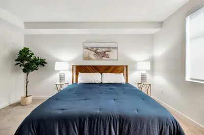 a bedroom with a large blue bed with two lamps at 5 Heart of Santa Monica apartment in Los Angeles