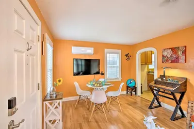 a living room with orange walls and a table and a desk at 7 Mi to Downtown Long Beach Bungalow with Patio! in Long Beach