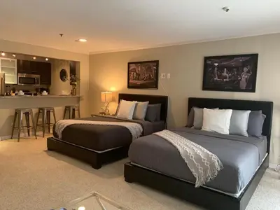 a bedroom with two beds and a kitchen with a bar at Hollywood loft spectacular free parking in Los Angeles