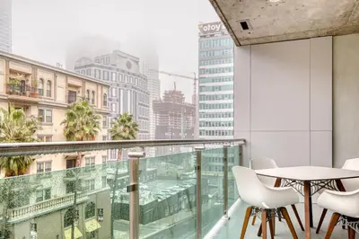 a balcony with a table and chairs and a view of a city at Downtown 1BR w Pool Gym WD nr Staples Center LAX-547 in Los Angeles