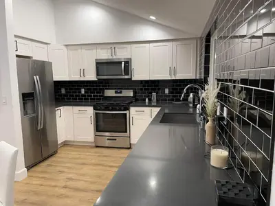 a kitchen with white cabinets and stainless steel appliances at Gated private house with own parking Sherman Oaks in Los Angeles