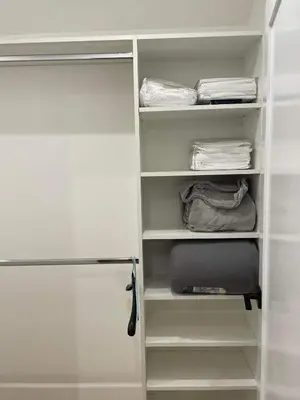 a closet with white shelves and a refrigerator at Gated private house with own parking Sherman Oaks in Los Angeles