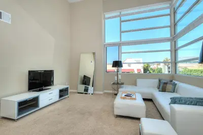 a living room with a white couch and a flat screen tv at Awesome Top Floor 2-Bedroom with Balcony in Los Angeles