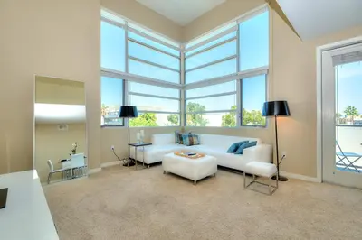 a living room with a white couch and some windows at Awesome Top Floor 2-Bedroom with Balcony in Los Angeles