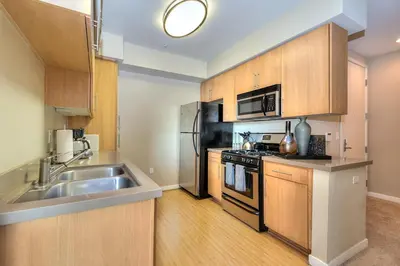 a kitchen with a sink and a stainless steel refrigerator at Awesome Top Floor 2-Bedroom with Balcony in Los Angeles