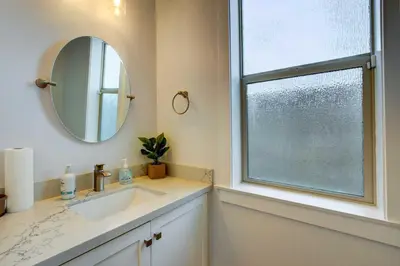 a bathroom with a sink and a mirror and a window at Pet-Friendly Paramount Home, 16 Mi to Los Angeles! in Paramount