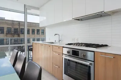 a kitchen with wooden cabinets and a stove top oven at Level Downtown LA South Olive in Los Angeles