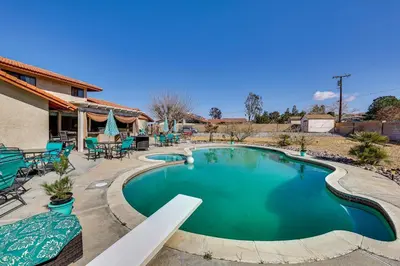 a swimming pool in a yard with tables and chairs at Spacious Apple Valley Home with Pool and Yard! in Apple Valley