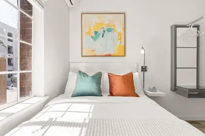a bedroom with a bed with colorful pillows at The Varden - A Self-Service Micro Hotel in Long Beach