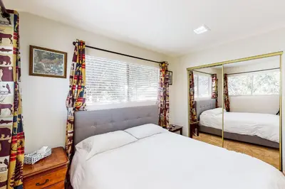 a bedroom with a bed and a mirror at Edelwiess Wonder in Crestline