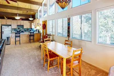 a kitchen and dining room with a wooden table and chairs at Edelwiess Wonder in Crestline