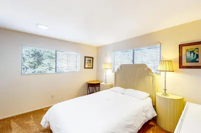 a bedroom with a white bed and two windows at Edelwiess Wonder in Crestline