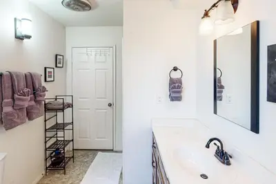 a white bathroom with a sink and a mirror at Edelwiess Wonder in Crestline