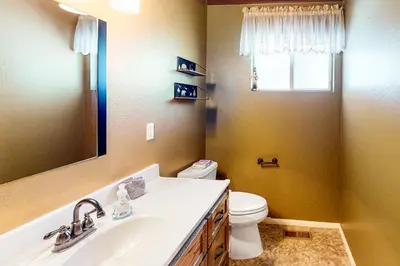 a bathroom with a sink and a toilet and a mirror at Edelwiess Wonder in Crestline