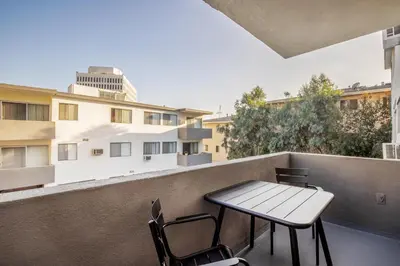 a table and chairs on a balcony with buildings at Brentwood 1BR w Outdoor Pool nr UCLA Downtown LAX-188 in Los Angeles