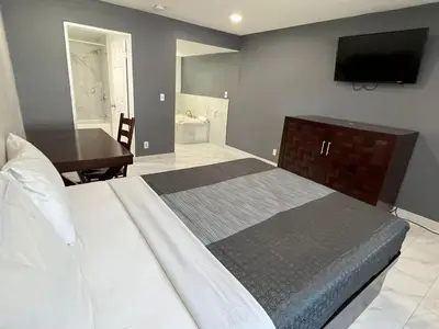 a bedroom with a bed and a desk and a television at Goldstar Inn in Los Angeles