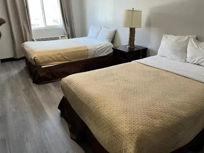 a hotel room with two beds and a window at Goldstar Inn in Los Angeles