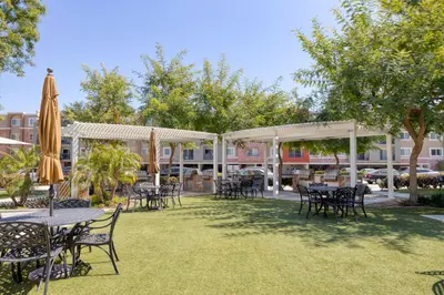 an outdoor patio with tables and chairs and umbrellas at Woodland Hills 2BR w Pool Gym nr Warner Center LAX-699 in Los Angeles