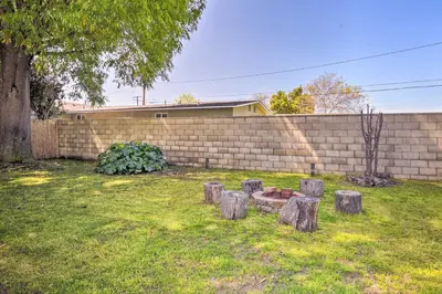a yard with a bunch of tree stumps in front of a wall at San Gabriel Valley Hideaway! Family Home with Patio in Temple City