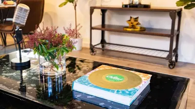 a glass table with a cd and flowers on it at Rock n Roll by AvantStay in Los Angeles