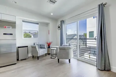 a living room with a table and chairs and a large window at Modern Apartment in Studio City in Los Angeles