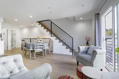 a living room with a staircase and a table and chairs at Modern Apartment in Studio City in Los Angeles