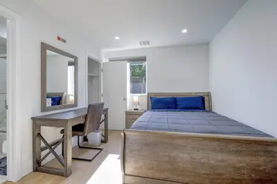 a bedroom with a bed and a desk and a mirror at Modern Apartment in Studio City in Los Angeles