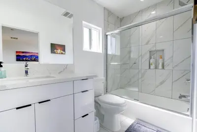 a white bathroom with a shower and a toilet at Modern Apartment in Studio City in Los Angeles