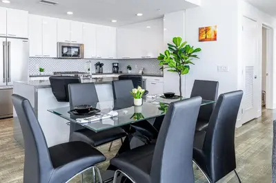a dining room with a glass table and black chairs at Top Floor High Rise 3 Bed DTLA Skyscraper Penthouse in Los Angeles