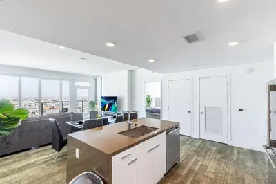 an open kitchen and living room with a couch at Top Floor High Rise 3 Bed DTLA Skyscraper Penthouse in Los Angeles